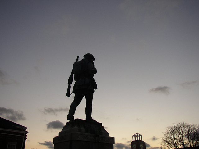 nadživotní socha vojáka v pochodu za západu slunce